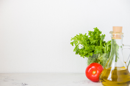 Olive oil, green salad lettuce and fresh tomato.の写真素材