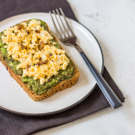 Scrambled eggs on whole wheat bread with avocado.の写真素材