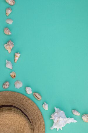 Hat and shells on a turquoise background, summer mood, empty space for textの写真素材