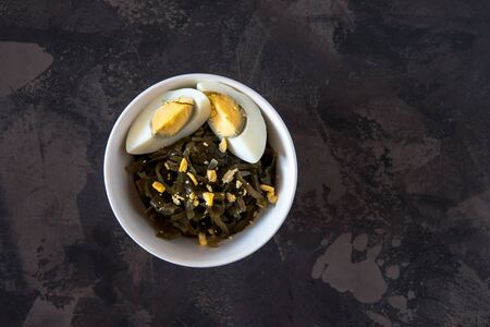 Far Eastern salad - sea kale with egg in a white cup topの写真素材