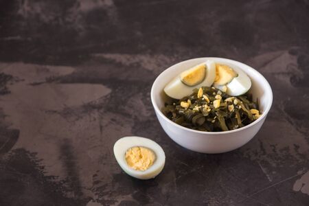 Far Eastern salad - sea kale with egg in a white cup topの写真素材
