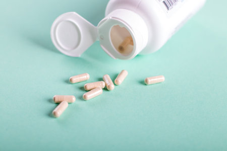 Pills, tablets and bottle on turquoise background. Copy space