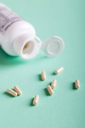 Pills, tablets and bottle on turquoise background. Copy spaceの写真素材