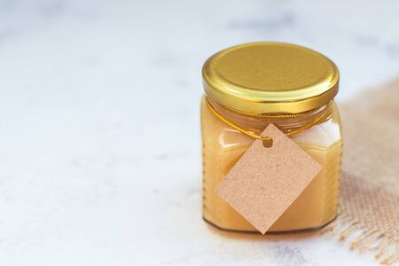 Honey in jar with empty paper label for your text or logoの写真素材