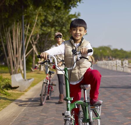 a Chinese boy riding bike with his motherの写真素材