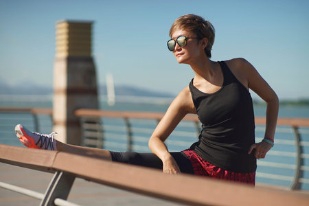 Chinese young woman doing stretch after jogging