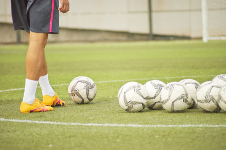 male player practicing soccer shooting alone in pitchの写真素材