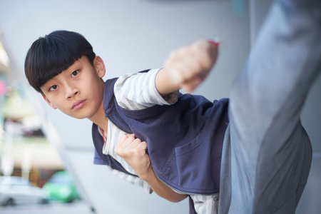 portrait of cool Asian kid playing marshal arts outdoors