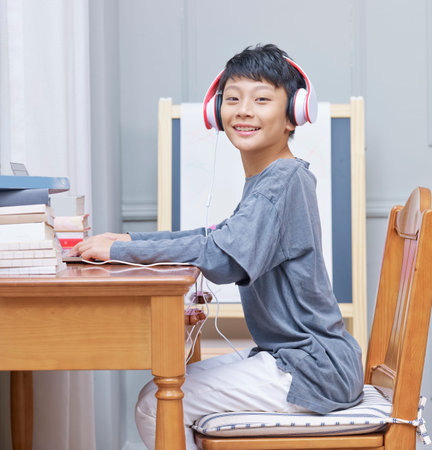 Asian teenage boy smiling at camera when surfing the net