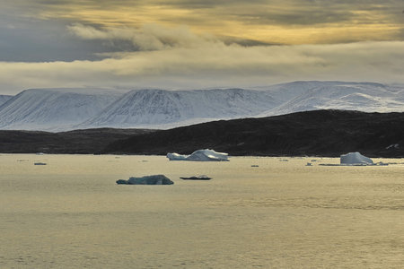 Global warming. Icebergs and mountains in the ocean.