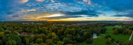 A beautiful start in the day. Sunset over Munichs English Garden as an aerial panorama shot.の写真素材