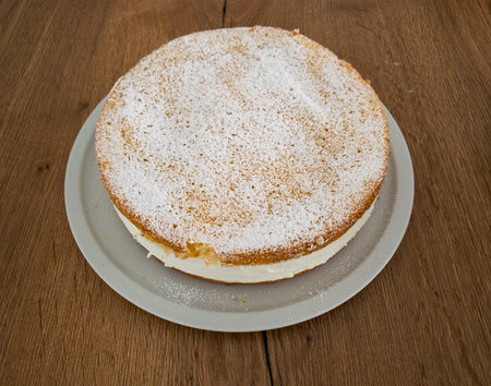 A complete, uncut delicious Cheese cake from a side view.