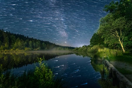 Comet modus - Stars flying over a beautiful lake with refections of the star clear night. Impressive nature scenery.の写真素材
