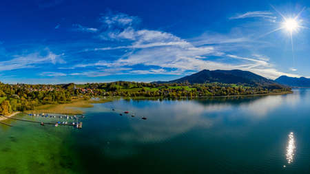 View over the beautyful landscape of the bavarian Tegernsee with boats at a web and the alp mountains in background.の写真素材