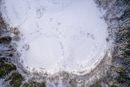 Aerial view of snow covered forest around beautiful lake. Scenic winter landscape in the south of the bavarian capital Munich.の写真素材