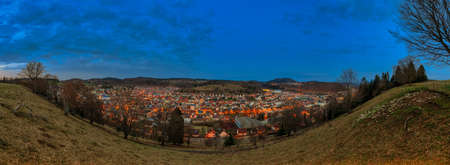 The illuminated city Albstadt at the recreation area of the Swabian Alb in panoramic view in the evening mood.の写真素材