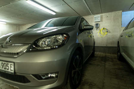 Electric car with its typical E at the number plate and a charging station Wallbox mounted at the wall in the background.の写真素材