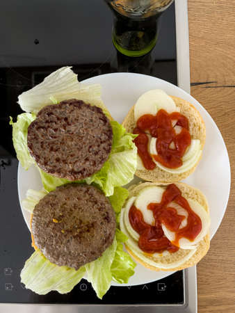 Top down view at a fresh eat ready, roasted pair of hamburgers, tasty prepared food from home.の写真素材