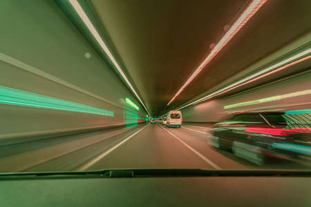 Highspeed blurred background, driving fast through a tunnel overtaking a car with light blurry long exposure effectsの写真素材