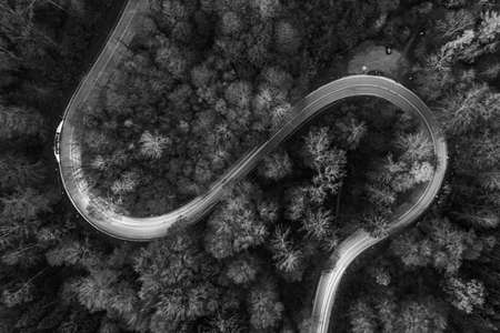 Curvy road from above with lighttrails of driving cars in black and white.の写真素材