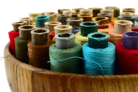 coloured threads in wooden plate isolated on whiteの写真素材