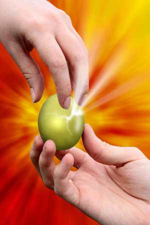 male hand giving easter golden egg to woman handの写真素材