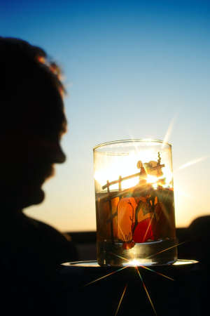philosophical question "To drink or not to drink". A man against the glass of vodka.  A glass is with picture of drunk cossack.の写真素材