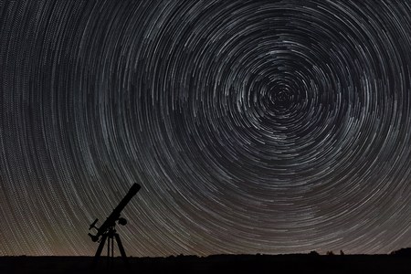 Beautiful night sky, Star trails over filed and astronomical telescopeの写真素材