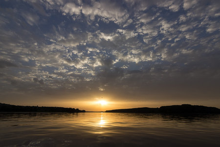 Travel to Sunset. Beautiful sunset at the river amazing colors, light beam shining through the...