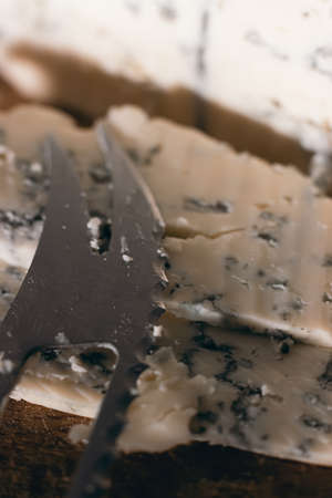 Blue cheese close up on an old wooden board and a knifeの写真素材