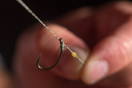 Man hand tying a fishing hook. Tie the rig.  Selective focus. Tie Hook Close Up. Tie Fishing Hook ...