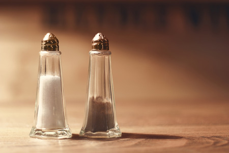 Salt and pepper shakers on wooden tableの写真素材