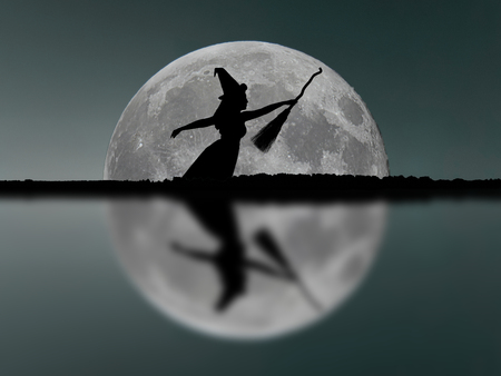 Halloween witch silhouette flying with broomstick. Full Moon. Reflection.の写真素材
