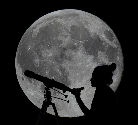 Silhouette of a woman with telescope full moon in the background.Moon Observing.の写真素材
