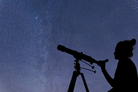 Woman with telescope watching the stars. Stargazing woman and night sky.の写真素材