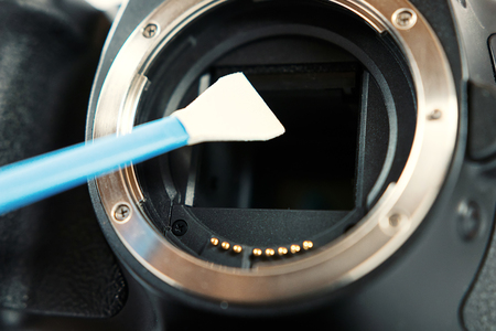 Digital photo camera with cleaning tools. Cleaning dirty camera sensor.の写真素材