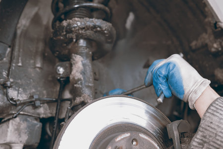 Hands of car mechanic in auto repair service.