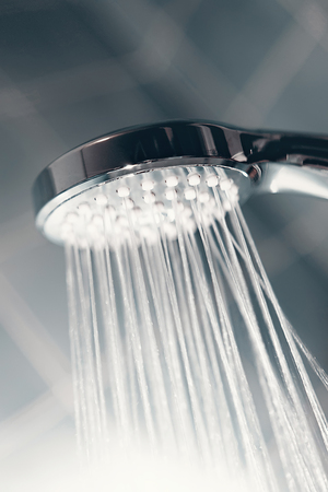 Shower head with flow of water spilling out closeup.
Modern shower head splashing water close up.の写真素材