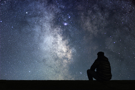 Man looking at the stars. Alone man looking at starry sky. Night sky.の写真素材