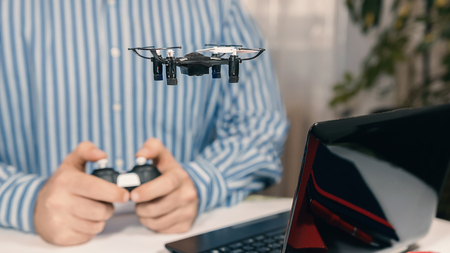 Businessman playing with drone toy to Relieve Stress at Work. Businessman testing new toy on desk in office. Office playing.の写真素材