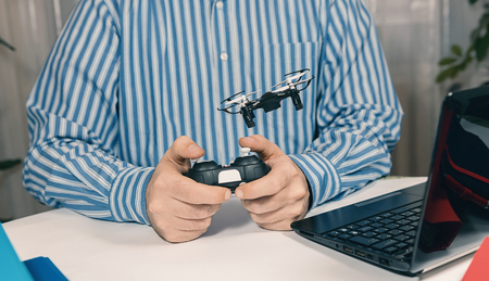 Businessman playing with drone toy to Relieve Stress at Work. Businessman testing new toy on desk in office.の写真素材