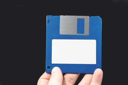 Computer floppy disk in Hand on black background.の写真素材