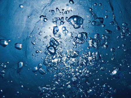 Underwater bubbles sunlight through water surface. Underwater background.