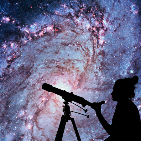 Girl looking at the stars with telescope. Messier 83, Southern Pinwheel Galaxy, M83 in the constellation Hydra.Elements of this image are furnished by NASA.の写真素材