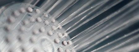 Shower head with flow of water spilling out closeup.Modern shower head splashing water close up.の写真素材