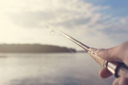Fishing rod and reel hand holding. Shallow depth of field.の写真素材