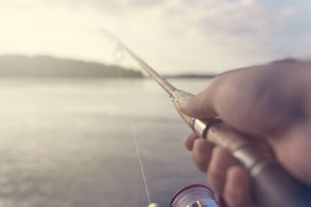 Fishing rod and reel hand holding. Shallow depth of field.の写真素材