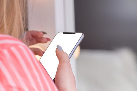 Close up of women's hands holding cell telephone with white screen