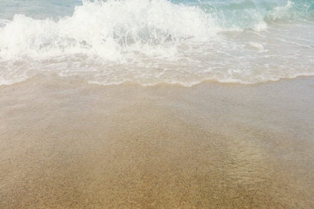 Wave of blue ocean on sandy beach close up Summer Background