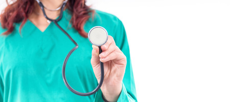 Female doctor in green lab coat holding stethoscopeの写真素材